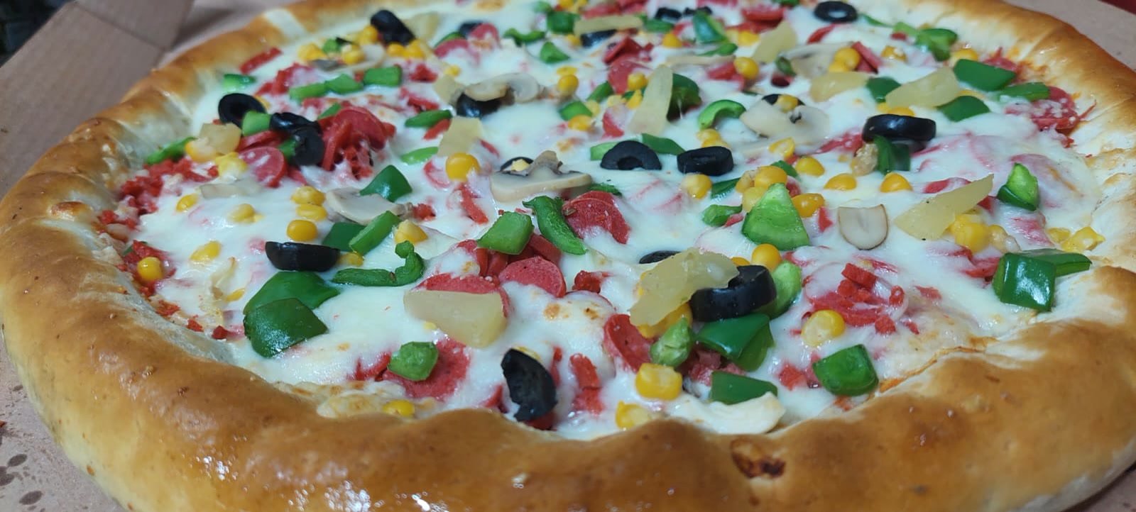 Pizza Time Majestical with sweet corn, olives, peppers and pineapple.