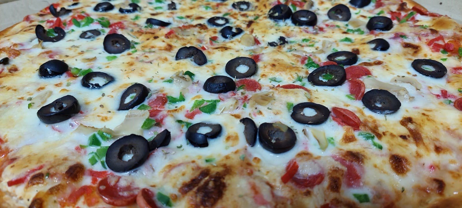 Milano pizza with beef sausages, paprika and olives.